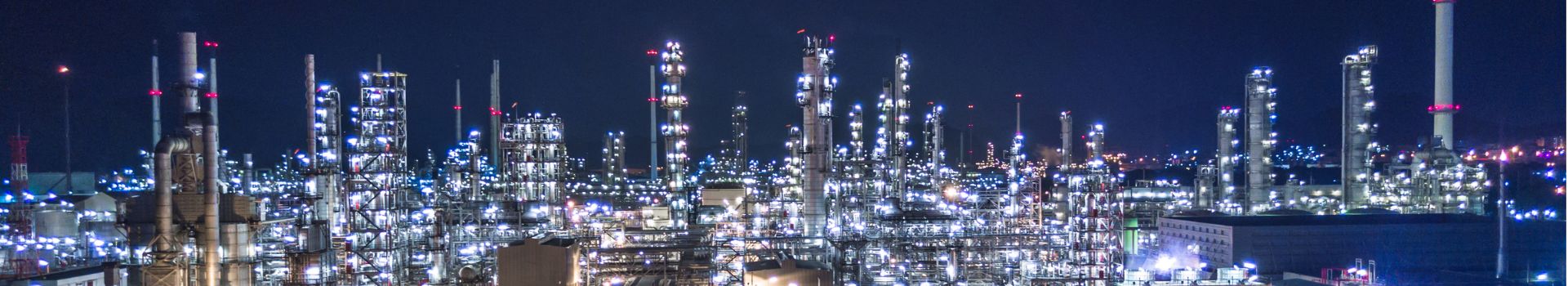 a highly lit up oil refinery at nighttime